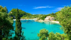 A distant view of Paleokastritsa Beach with its crystal-clear green and blue waters